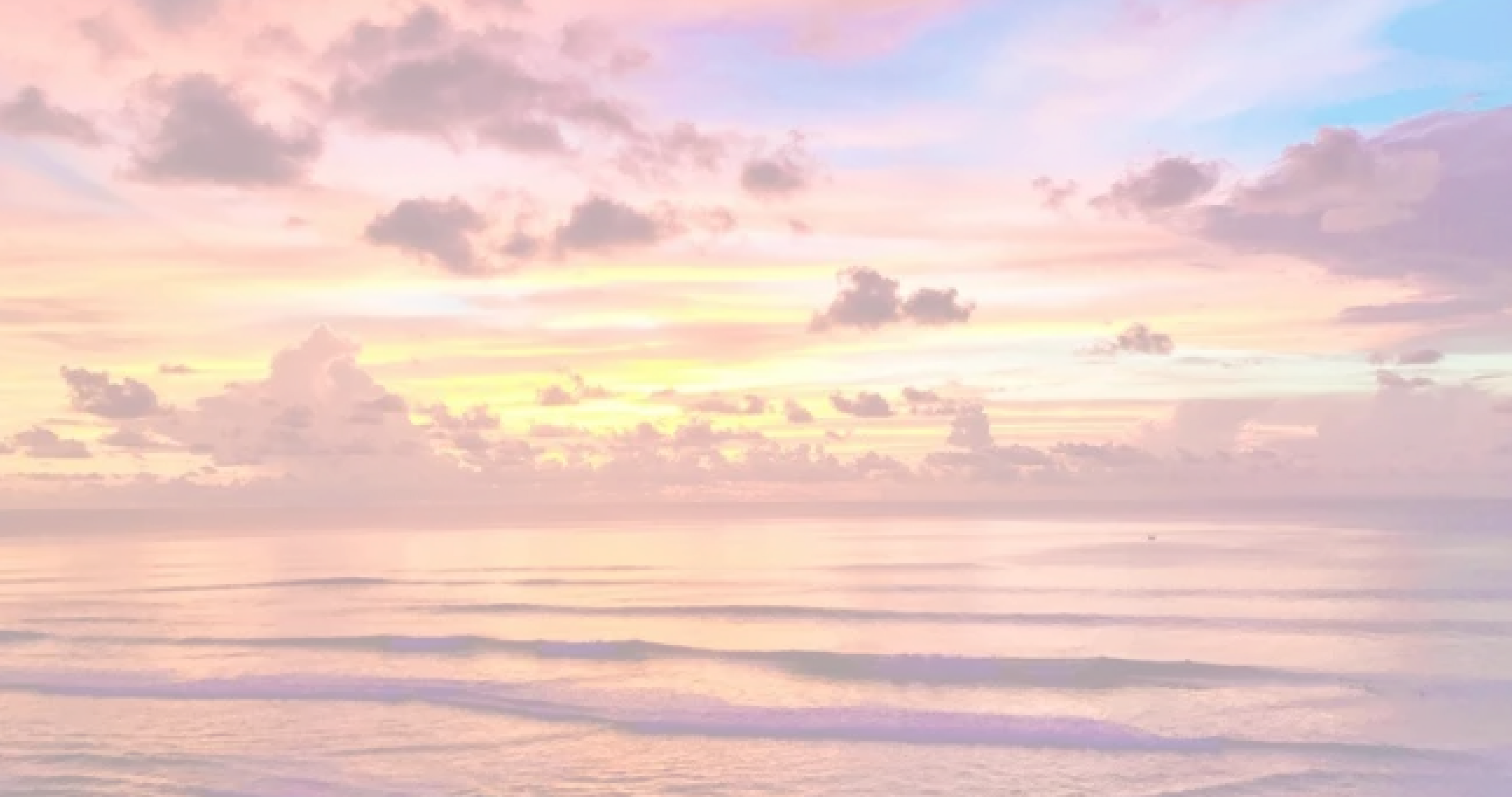 Soft pastel sunset seascape with pink, peach, and lavender clouds over calm ocean waves.